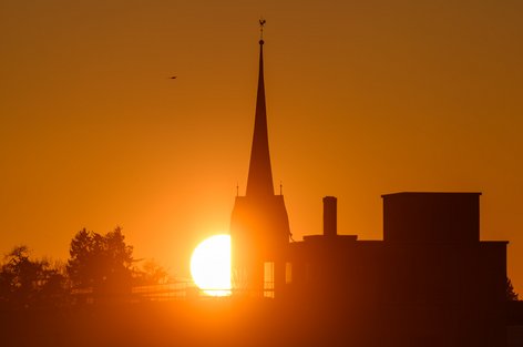 Sonnenuntergang hinter der reformierten Kirche und Alterszentrum Breitlen